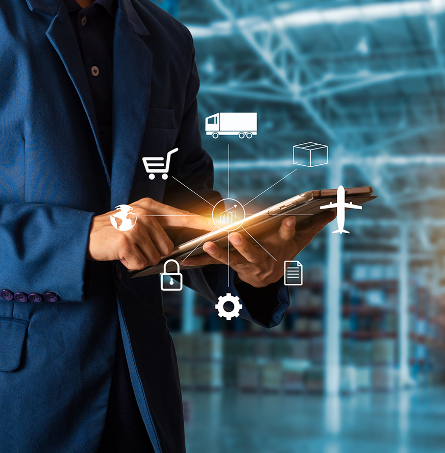 Person in a suit using a tablet, with logistics and supply chain icons superimposed, standing in a warehouse environment.