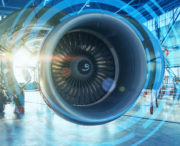 Close-up view of a jet engine inside an aircraft hangar, with digital blue circular graphics overlaying the image.